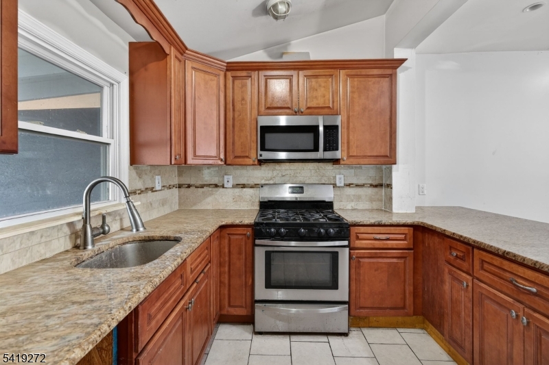 136 Smith Street Elizabeth, NJ 07201 - Photo 12 of 45 a kitchen with stainless steel appliances granite countertop a stove microwave and sink