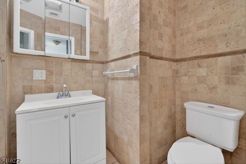 136 Smith Street Elizabeth, NJ 07201 - Photo 18 of 45 a bathroom with a toilet sink and mirror