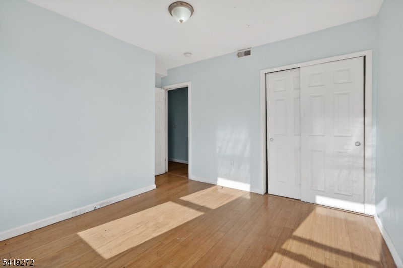 136 Smith Street Elizabeth, NJ 07201 - Photo 23 of 45 an empty room with wooden floor and windows