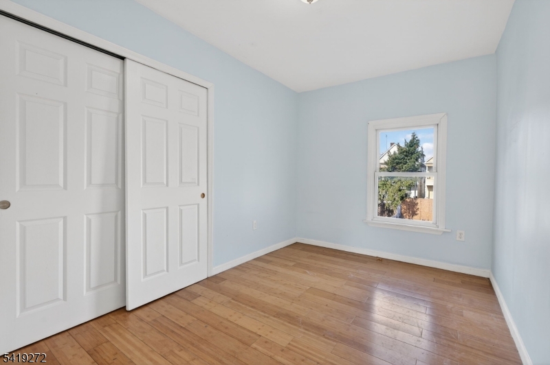136 Smith Street Elizabeth, NJ 07201 - Photo 24 of 45 a view of an empty room with wooden floor and a window