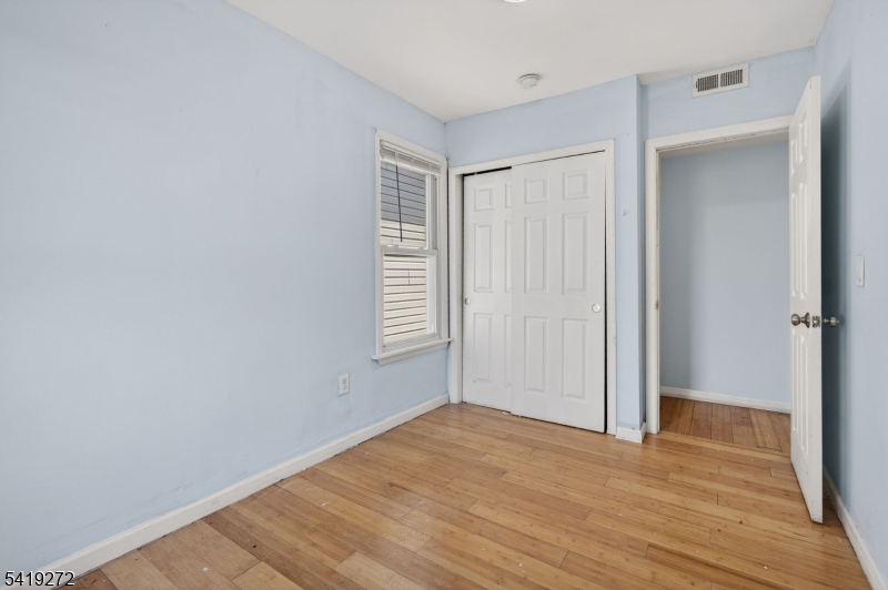 136 Smith Street Elizabeth, NJ 07201 - Photo 31 of 45 a view of an empty room with wooden floor and a window