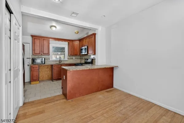 a kitchen with stainless steel appliances granite countertop a stove a sink and a refrigerator