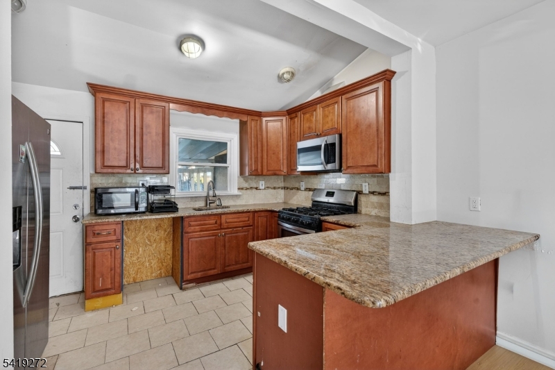 136 Smith Street Elizabeth, NJ 07201 - Photo 10 of 45 a kitchen with stainless steel appliances granite countertop a stove a sink dishwasher a refrigerator and a microwave oven