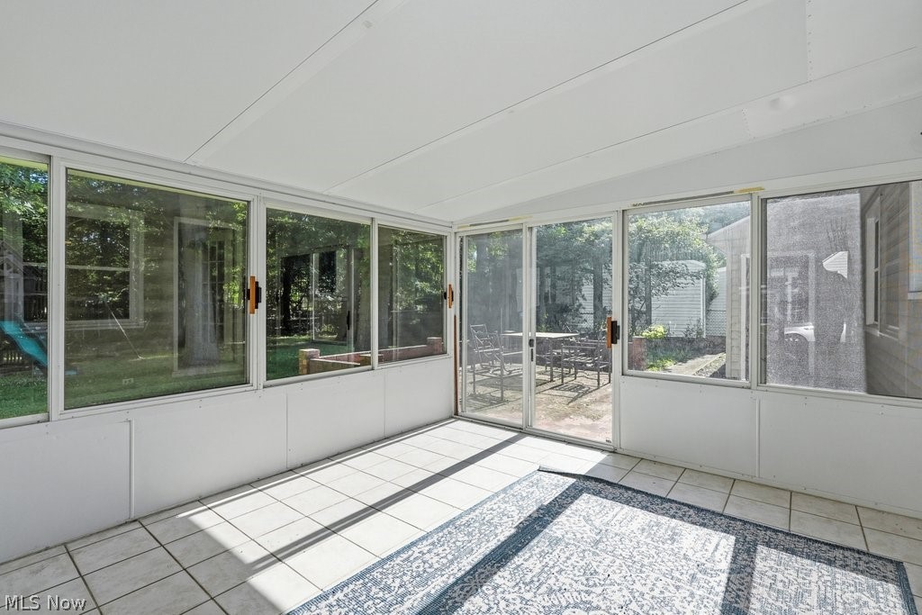 136 Pinehurst Road Munroe Falls, OH 44262 - Photo 30 of 48 Sunroom with tiled flooring, white ceiling, and multiple sliding glass doors leading to an outdoor patio with a paved surface