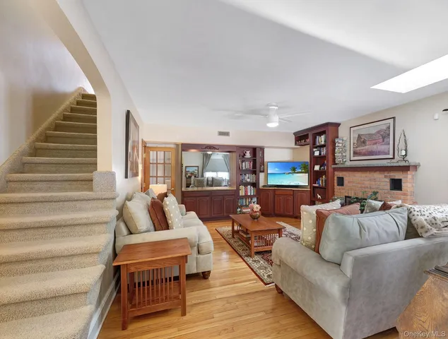 a living room with furniture a flat screen tv and wooden floor