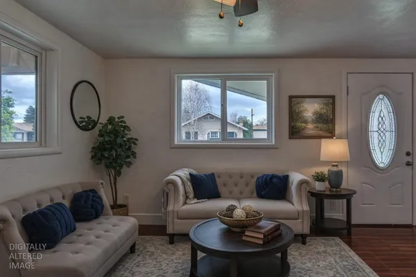 a living room with furniture a window and a potted plant