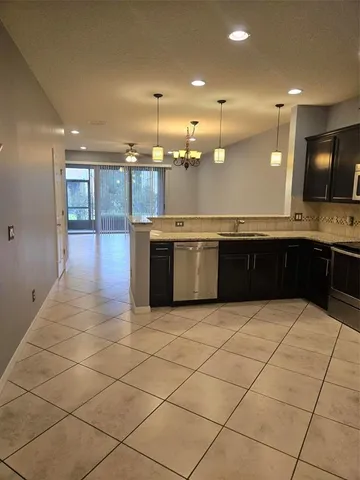 a large kitchen with kitchen island granite countertop a sink and a stove