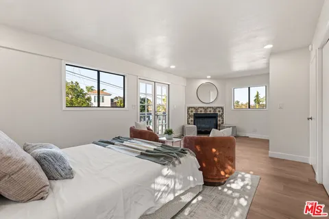 a bedroom with a bed window table and chair