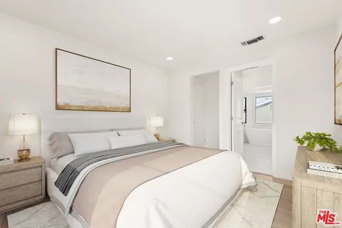 a bedroom with a bed and a potted plant