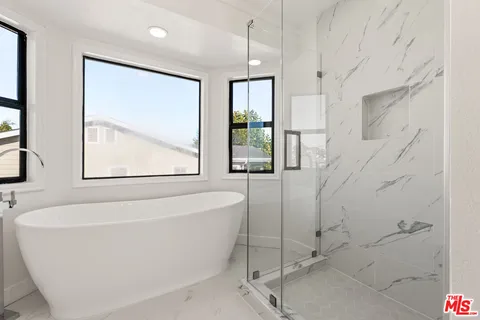 a white bath tub sitting next to a shower