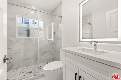 a bathroom with a sink a toilet and shower