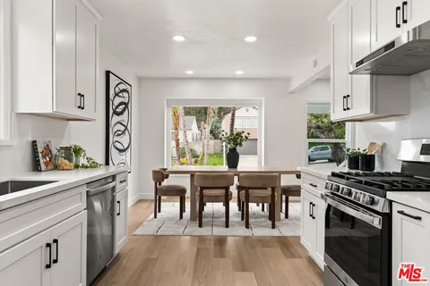 a kitchen with stainless steel appliances granite countertop a stove and a wooden floors