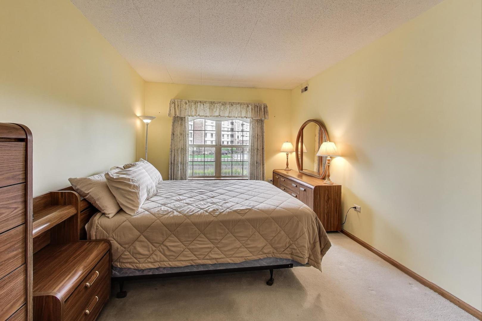 1200 South Prospect Avenue, Unit 108 Elmhurst, IL 60126 - Photo 13 of 19 a bedroom with a bed and window