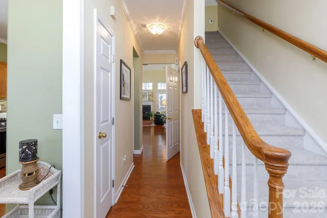 a view of a hallway with wooden floor and stairs