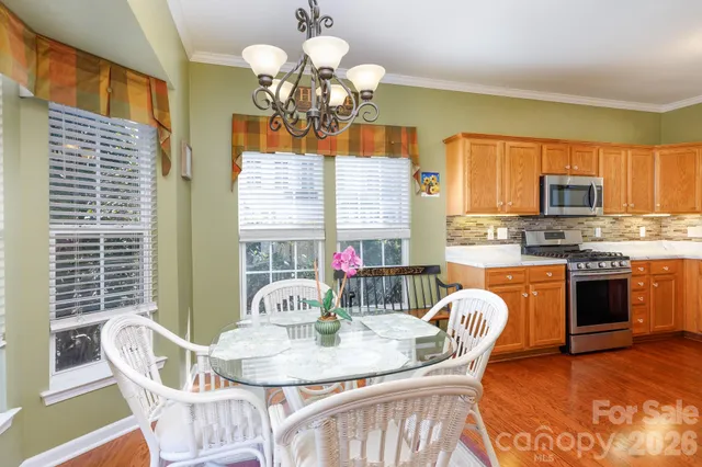 a view of a dining room with furniture a chandelier and wooden floor
