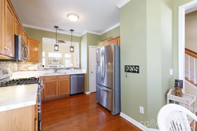 a kitchen with stainless steel appliances granite countertop a refrigerator and a sink