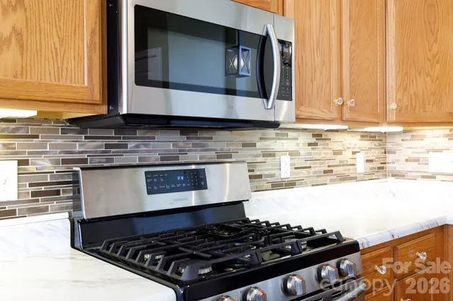a kitchen with stainless steel appliances granite countertop a stove and a microwave