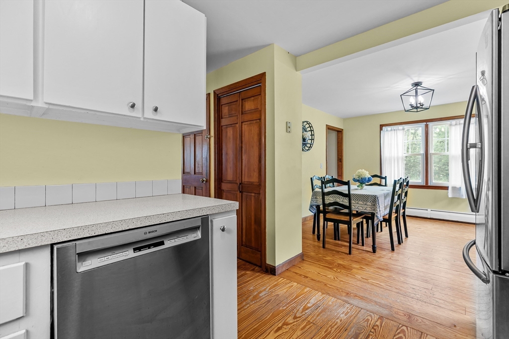 140 I Long Highway Little Compton, RI 02837 - Photo 12 of 41 a kitchen with a table chairs refrigerator and cabinets
