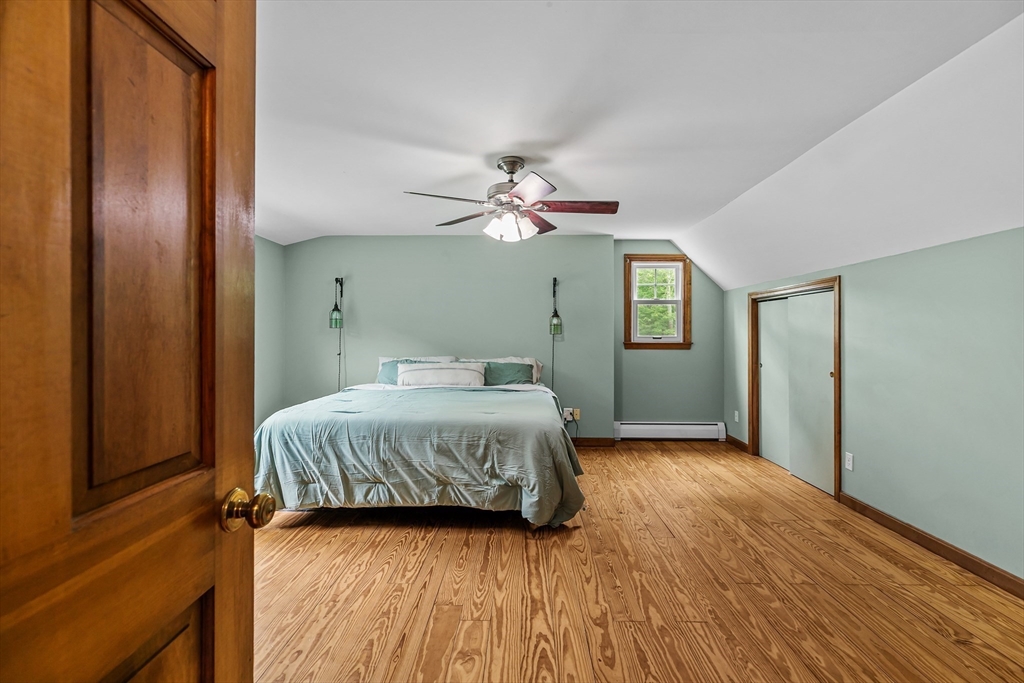 140 I Long Highway Little Compton, RI 02837 - Photo 18 of 41 a bedroom with a large bed and a chandelier