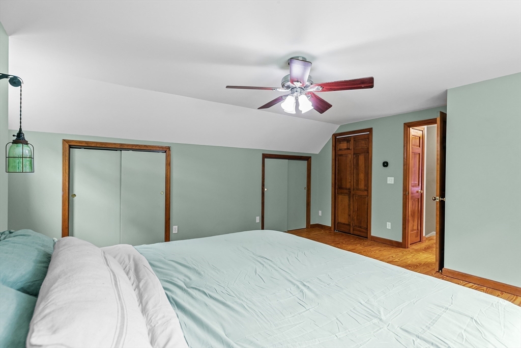 140 I Long Highway Little Compton, RI 02837 - Photo 20 of 41 a bedroom with a large bed and a chandelier