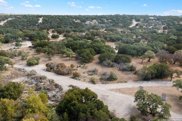 an aerial view of residential houses with outdoor space and trees