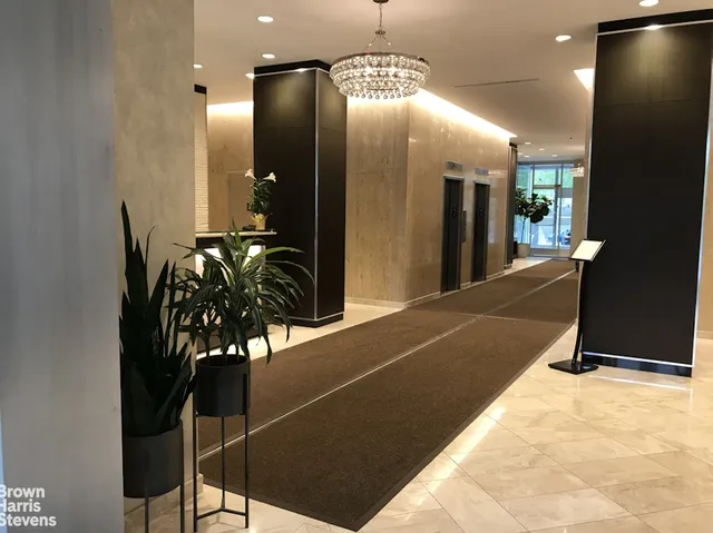 a lobby with a couch and a potted plant