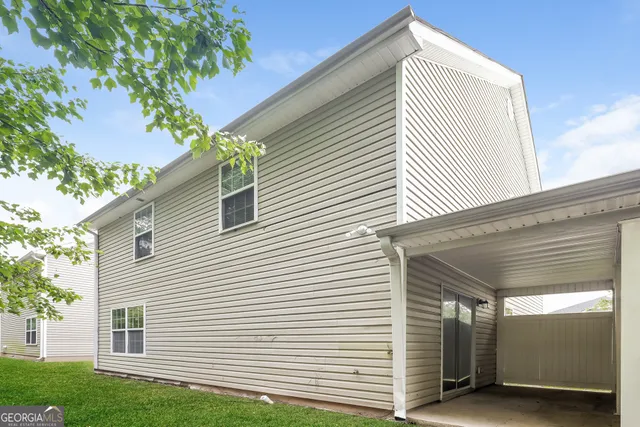 a view of a white house with a yard and plants
