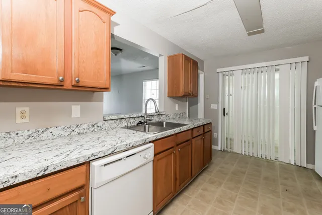 a kitchen with granite countertop a sink and a stove
