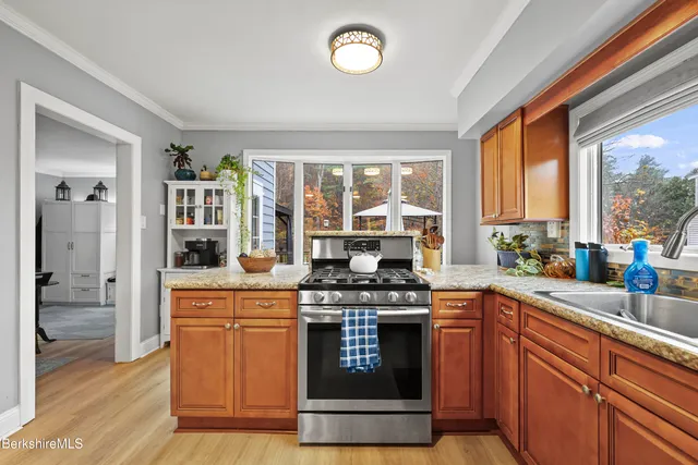 a kitchen with stainless steel appliances granite countertop a stove a sink and a granite countertops with cabinets