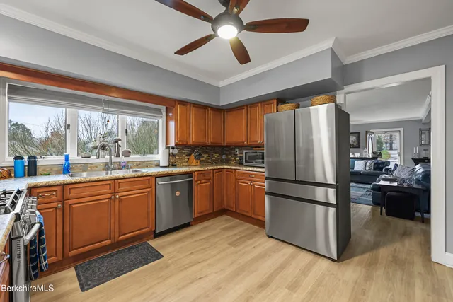 a kitchen with granite countertop appliances a sink and a large window