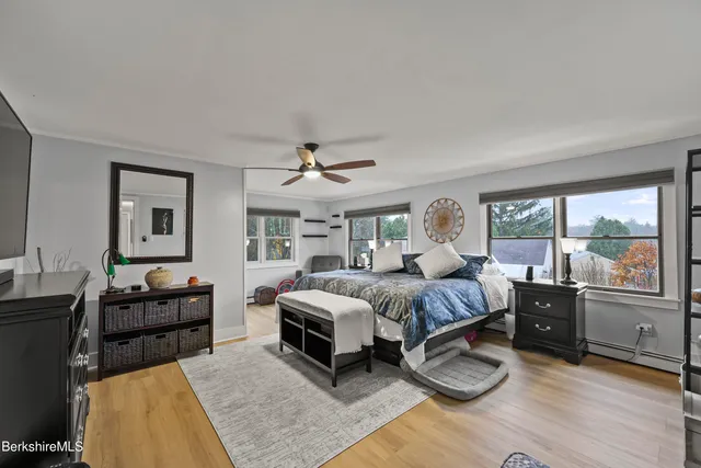 a spacious bedroom with a bed and wooden floor