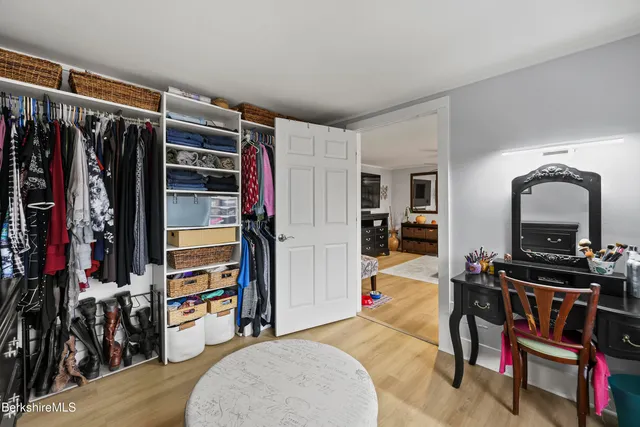a view of walk in closet with clothes and shoes