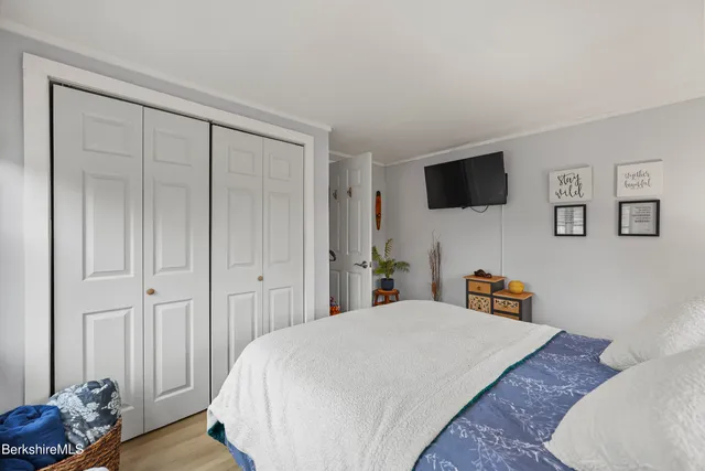 a spacious bedroom with a bed and a flat screen tv