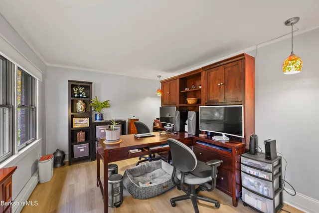 a view of a workspace with furniture and a window