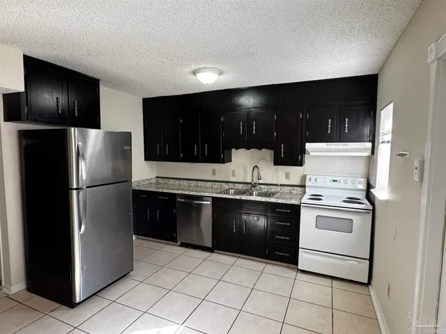 a kitchen with stainless steel appliances granite countertop a refrigerator and a stove