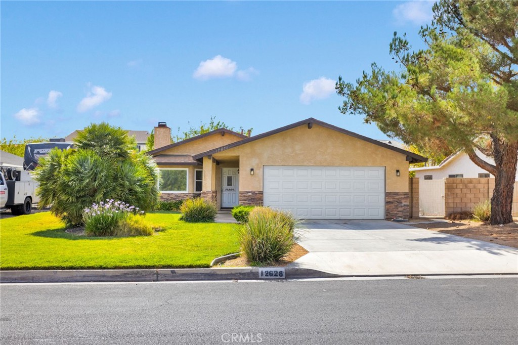 12628 Rain Shadow Road Victorville, CA 92395 - Photo 1 of 1 a front view of a house with a yard and garage