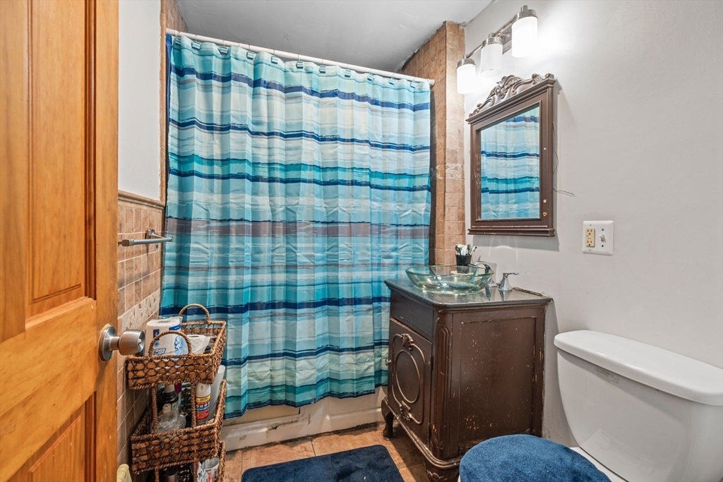 385 Centre Street, Unit 1 Boston, MA 02122 - Photo 7 of 14 a bathroom with a toilet a sink and a shower