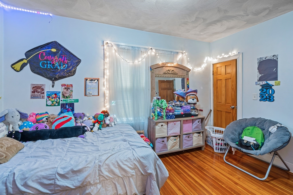 385 Centre Street, Unit 1 Boston, MA 02122 - Photo 9 of 14 a bedroom with bed and wooden floor
