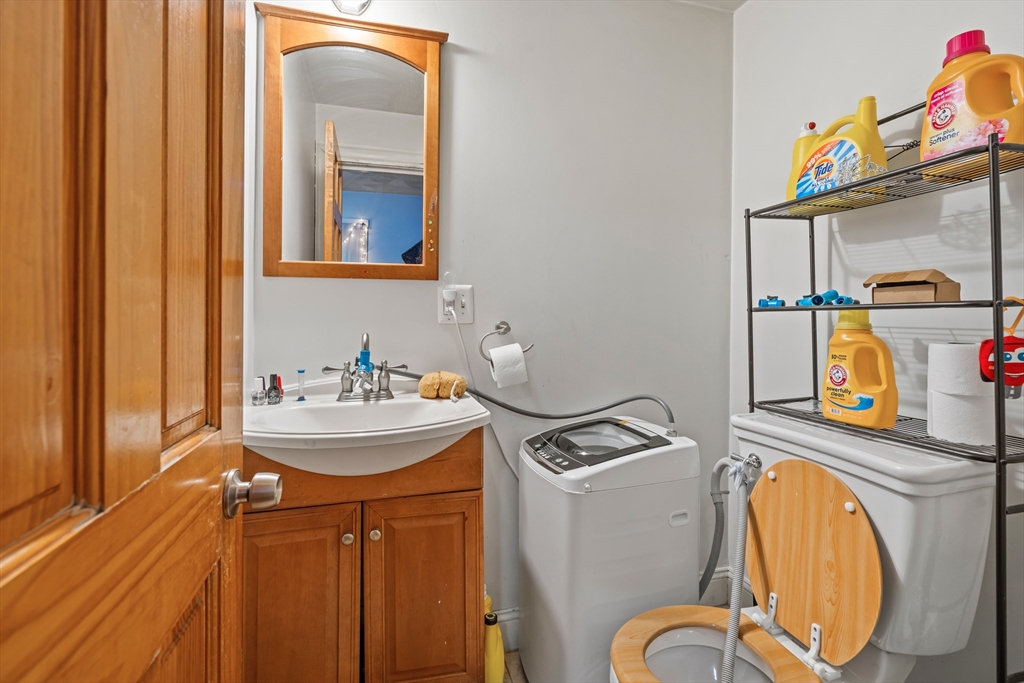 385 Centre Street, Unit 1 Boston, MA 02122 - Photo 10 of 14 a bathroom with a sink mirror and toilet