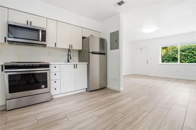 a kitchen with stainless steel appliances a stove microwave and sink