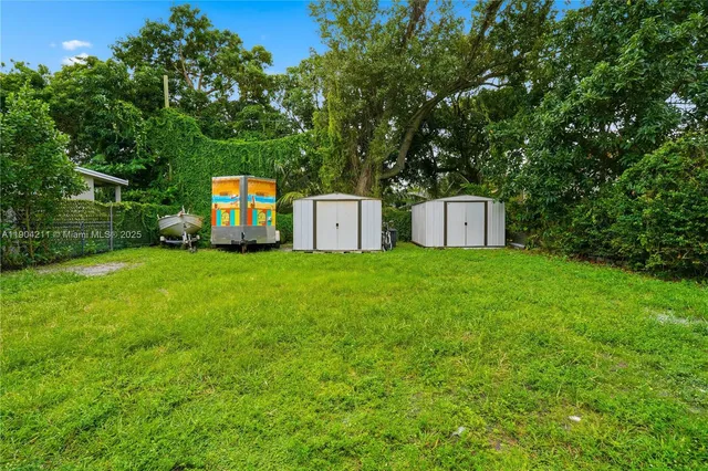 an aerial view of residential houses with outdoor space and trees