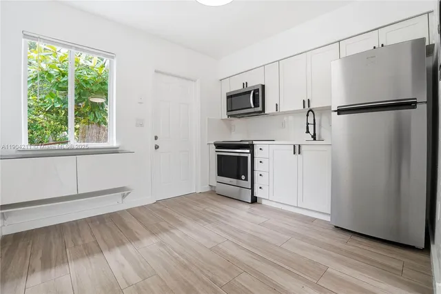 a view of empty room with wooden floor and window