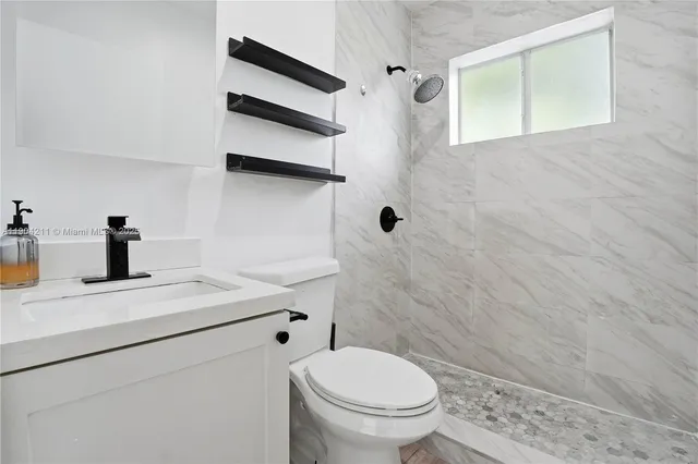 a bathroom with a sink a toilet and a mirror