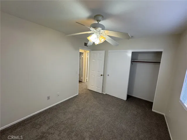 an empty room with a window and a ceiling fan