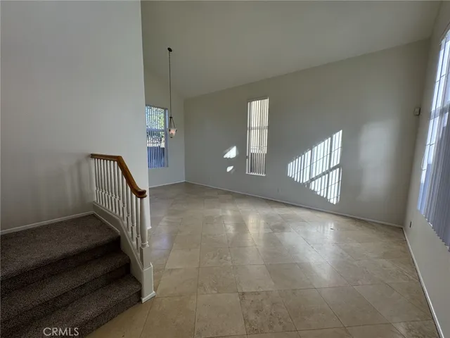 a view of an empty room with stairs and a window