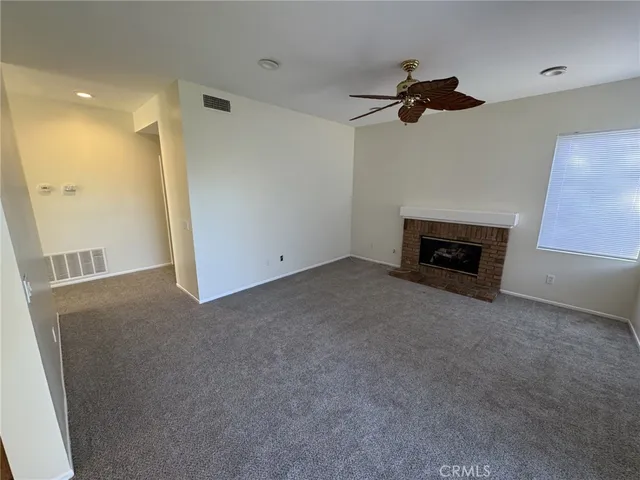 a view of a livingroom with a fireplace and a ceiling fan