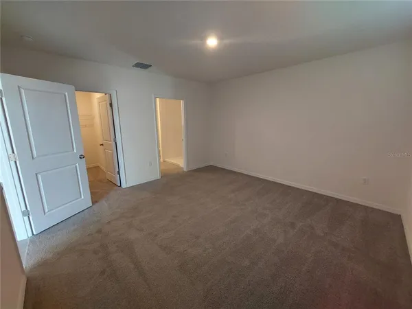 an empty room with windows and closet