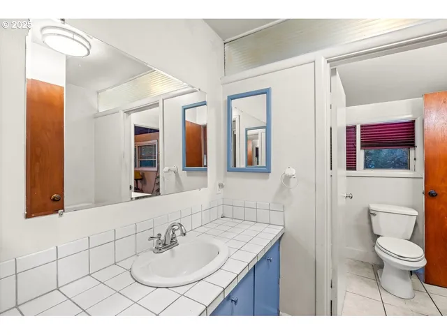 a bathroom with a tub a sink and a mirror