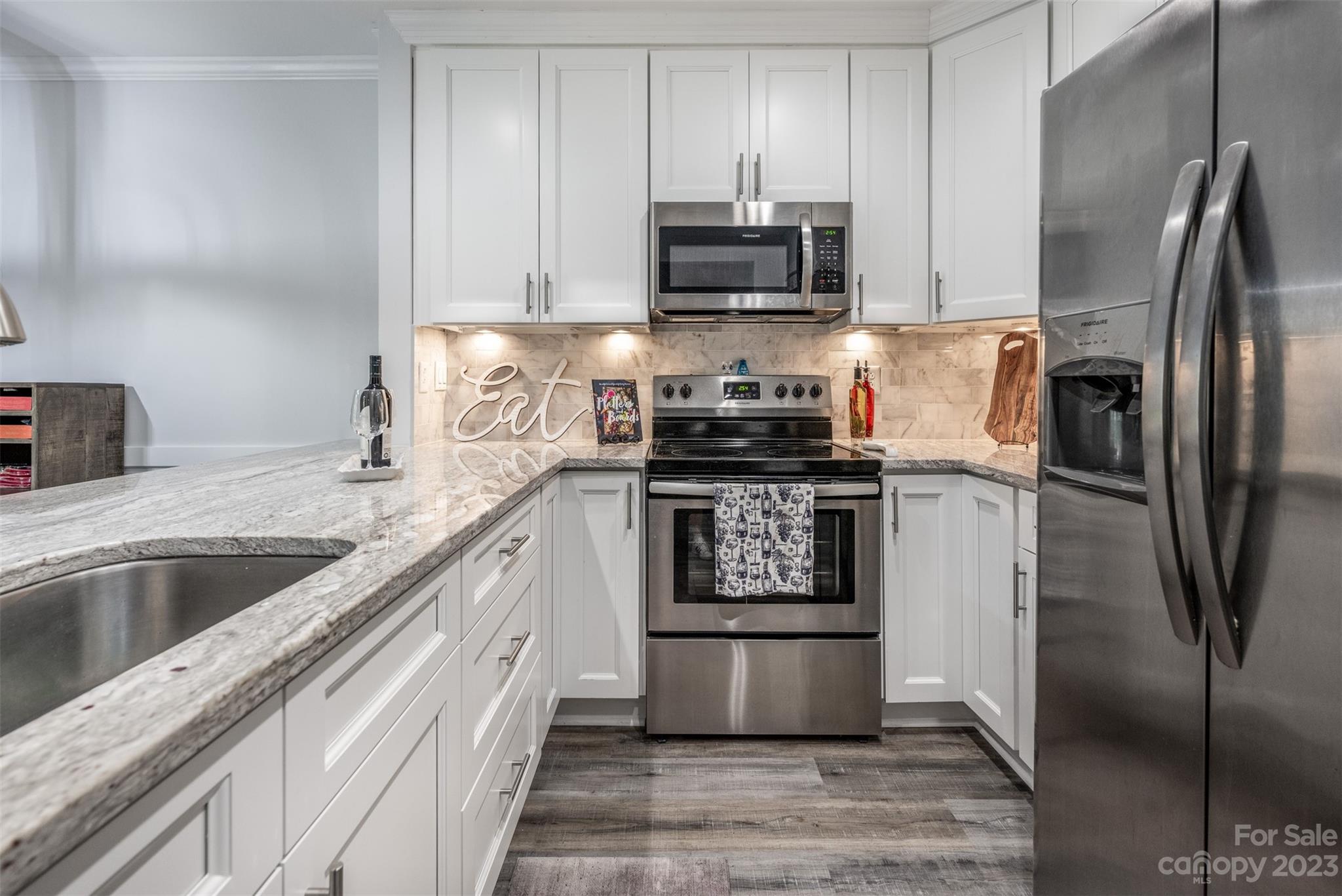 20101 Henderson Road, Unit H Cornelius, NC 28031 - Photo 12 of 48 a kitchen with stainless steel appliances granite countertop a refrigerator a stove and a sink with wooden floor
