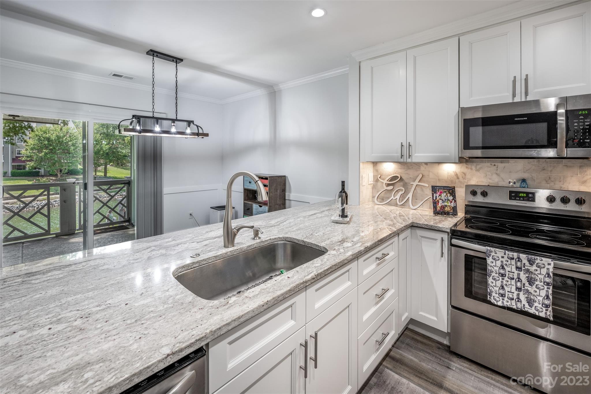 20101 Henderson Road, Unit H Cornelius, NC 28031 - Photo 13 of 48 a kitchen with stainless steel appliances granite countertop a sink stove and microwave